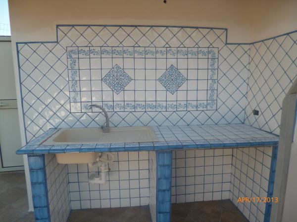 Cucina in muratura, con piastrelle color azzurro-bianco lucido