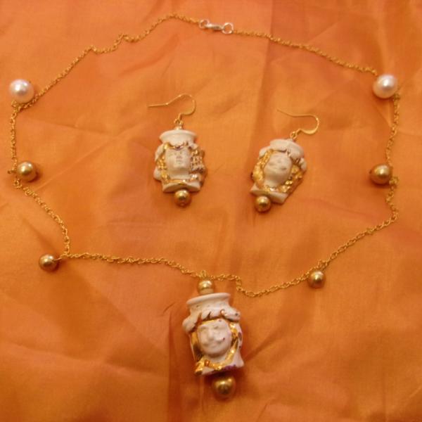 Collana ed orecchini con teste di moro, di colore bianco-dorato