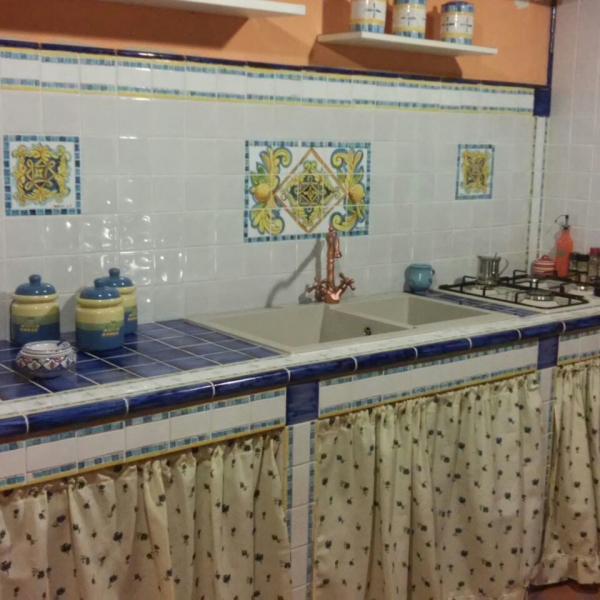 Cucina in muratura, con quadri su piastrelle, vista frontale