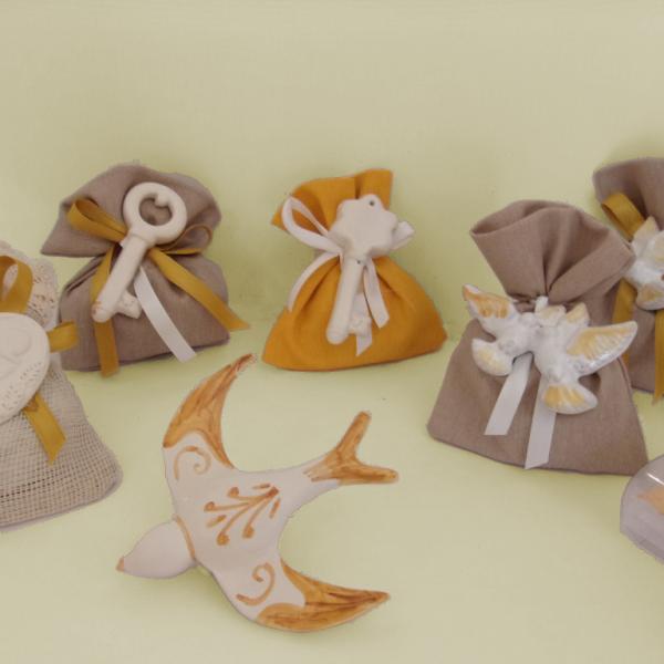 Rondine, sacchetti di confetti con simbolo tau, colombe e chiavi